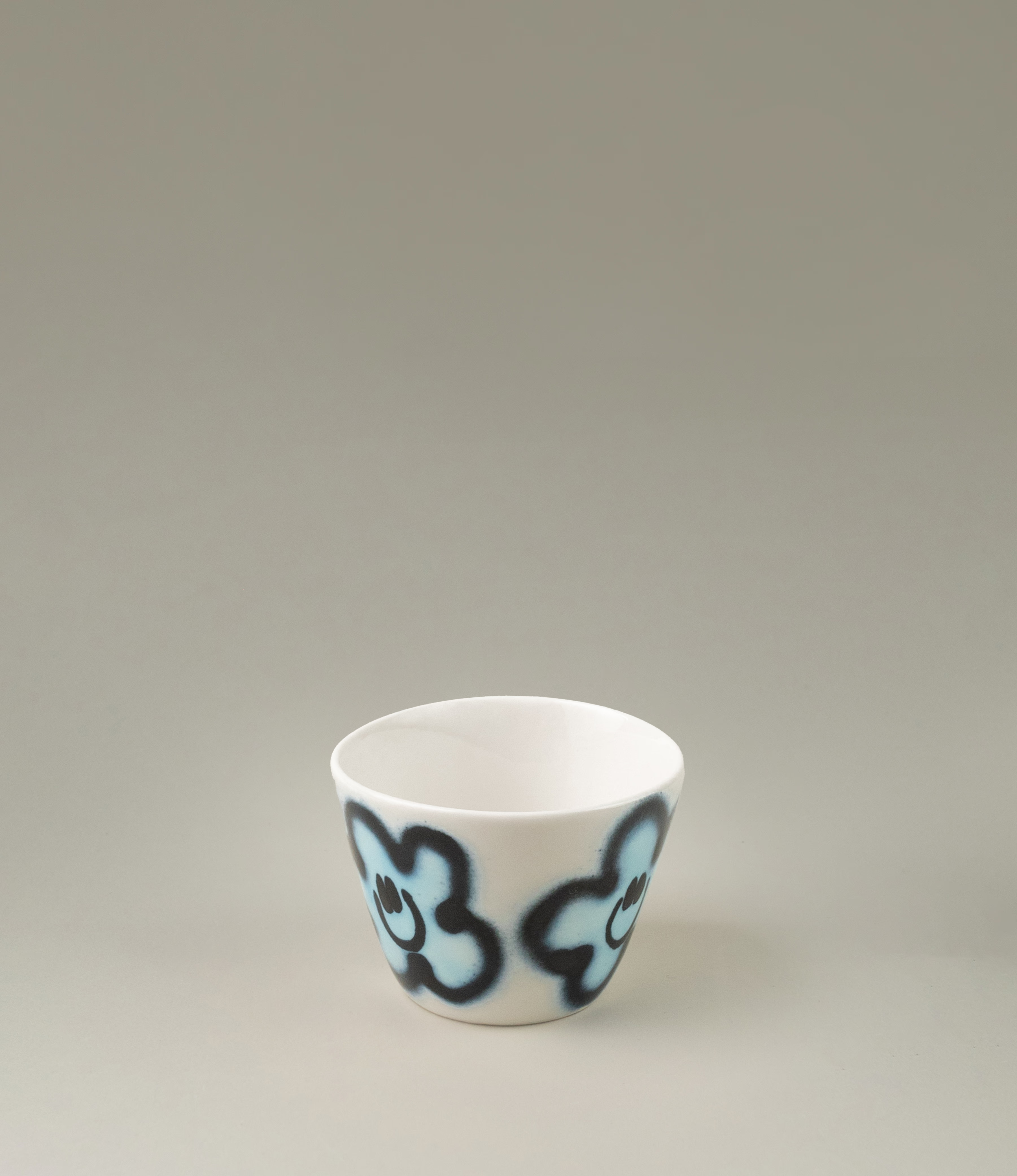 Super Cup from Frizbee Ceramics. The cup's base is white with a blue flower smiley.