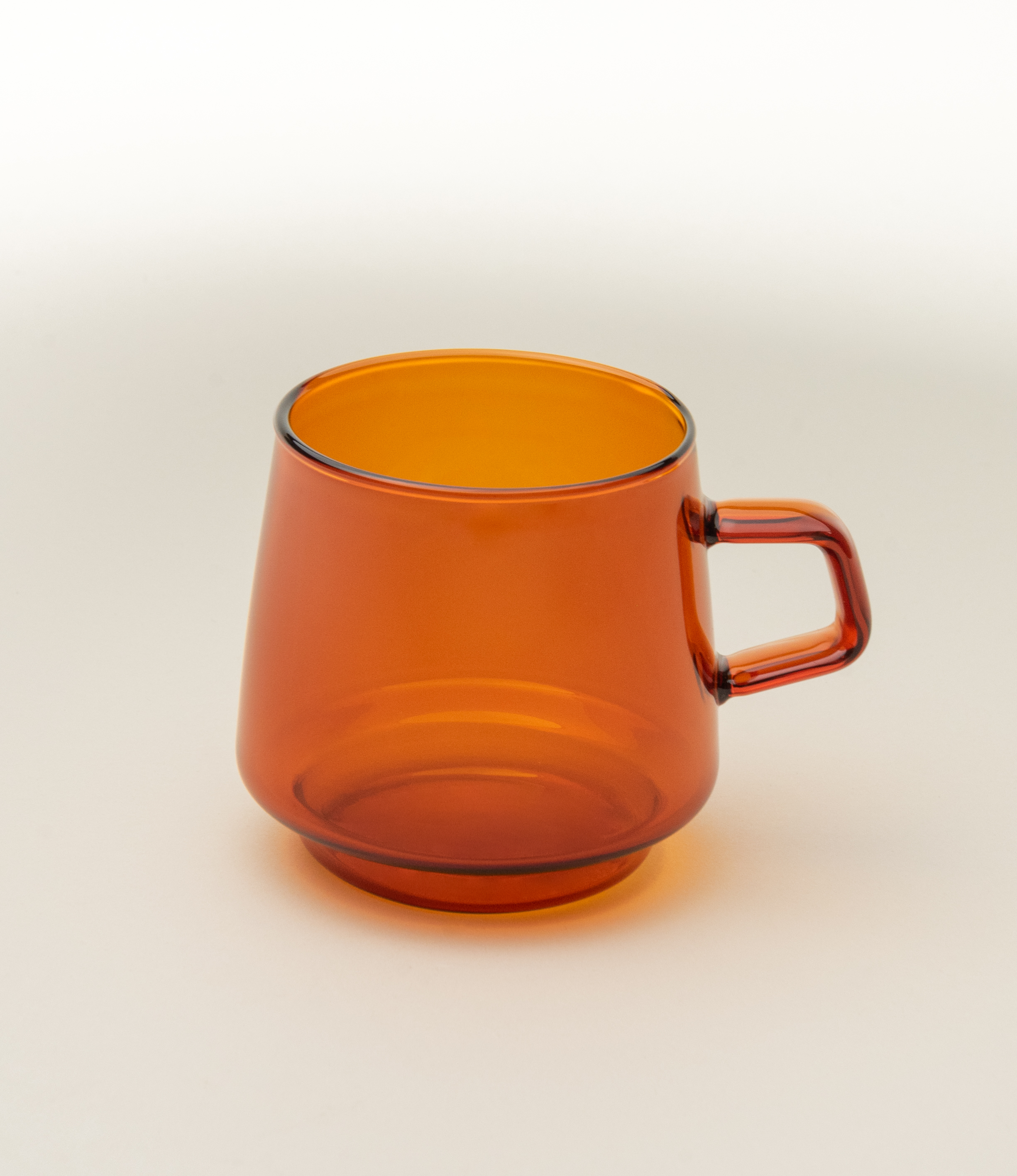 Sepia Mug is a glass mug from the japanese brand Kinto. The item is coming in the popular amber color which fits well the nostalgic shape of the product. The product has a small handle on the side.