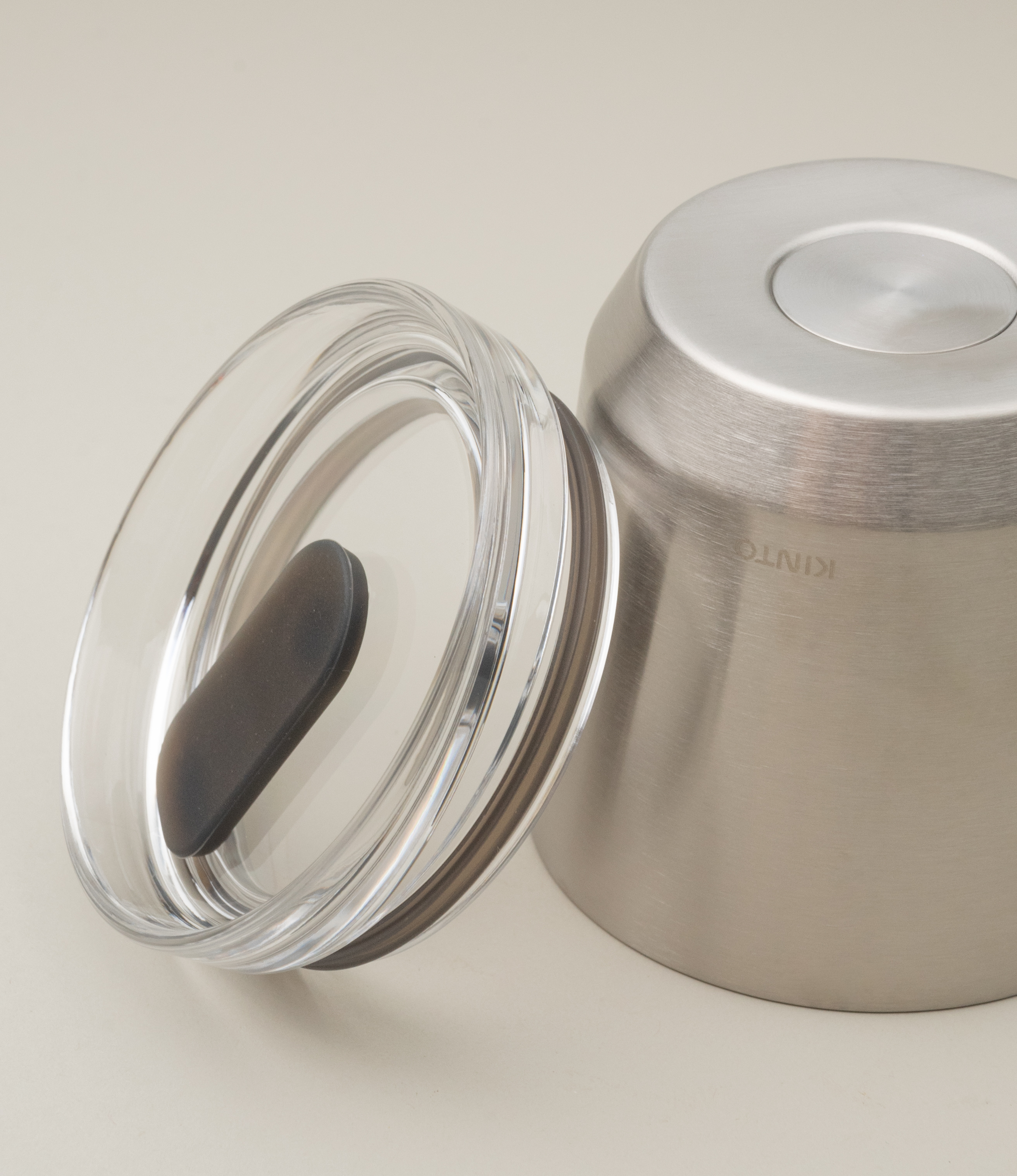 A takeaway cup from the japanese brand 'Kinto'. The To Go Tumbler is a matte stainless steel item, leak proof with a clear top part. The item retains the temperature and taste of your drink.