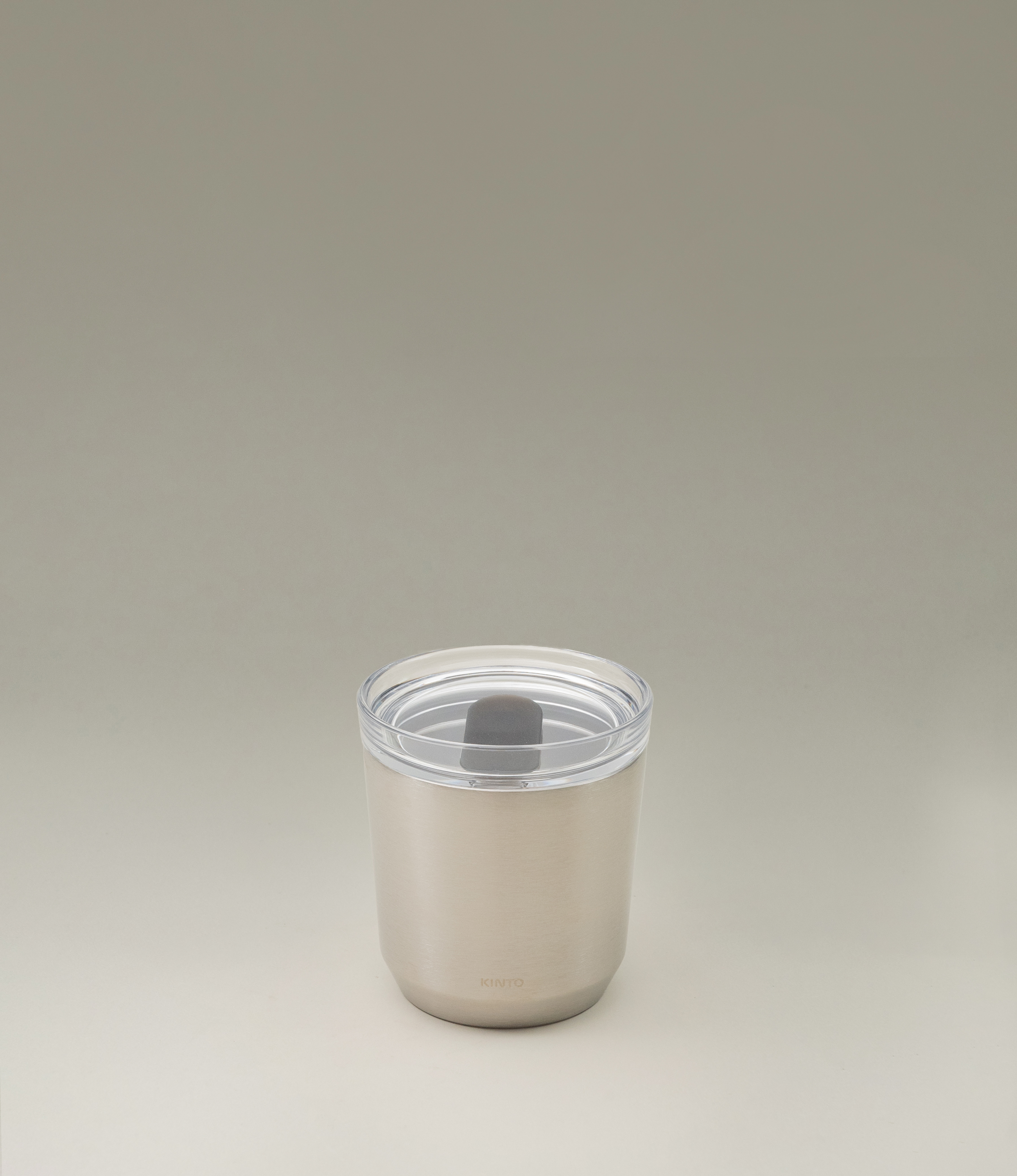 A takeaway cup from the japanese brand 'Kinto'. The To Go Tumbler is a matte stainless steel item, leak proof with a clear top part. The item retains the temperature and taste of your drink.