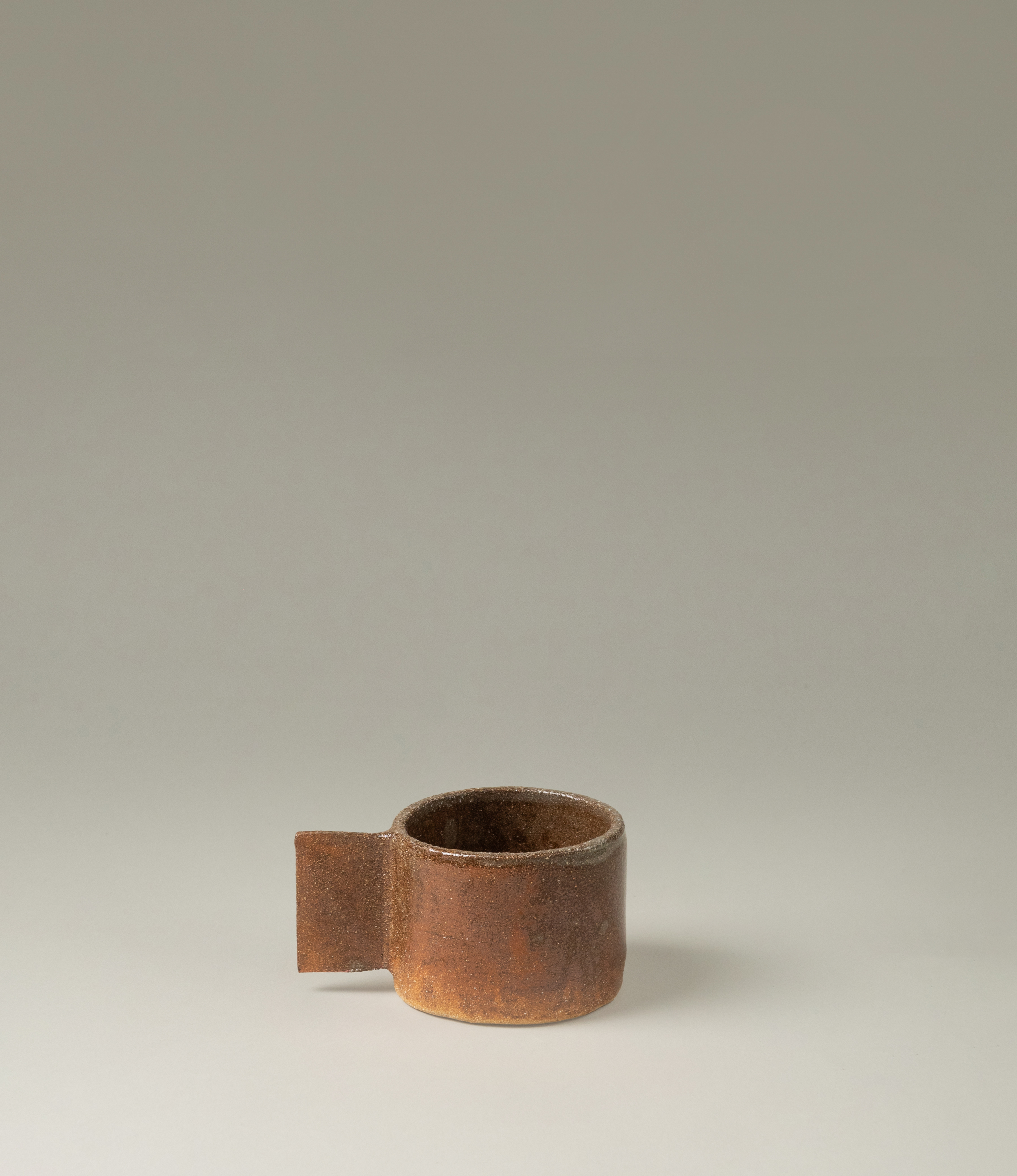 Ceramic cup from Manamo Cup. The item comes in the soothing earthy coffee color. The handle has an unusual rectangle shape which makes the modern touch to the natural tone and texture.