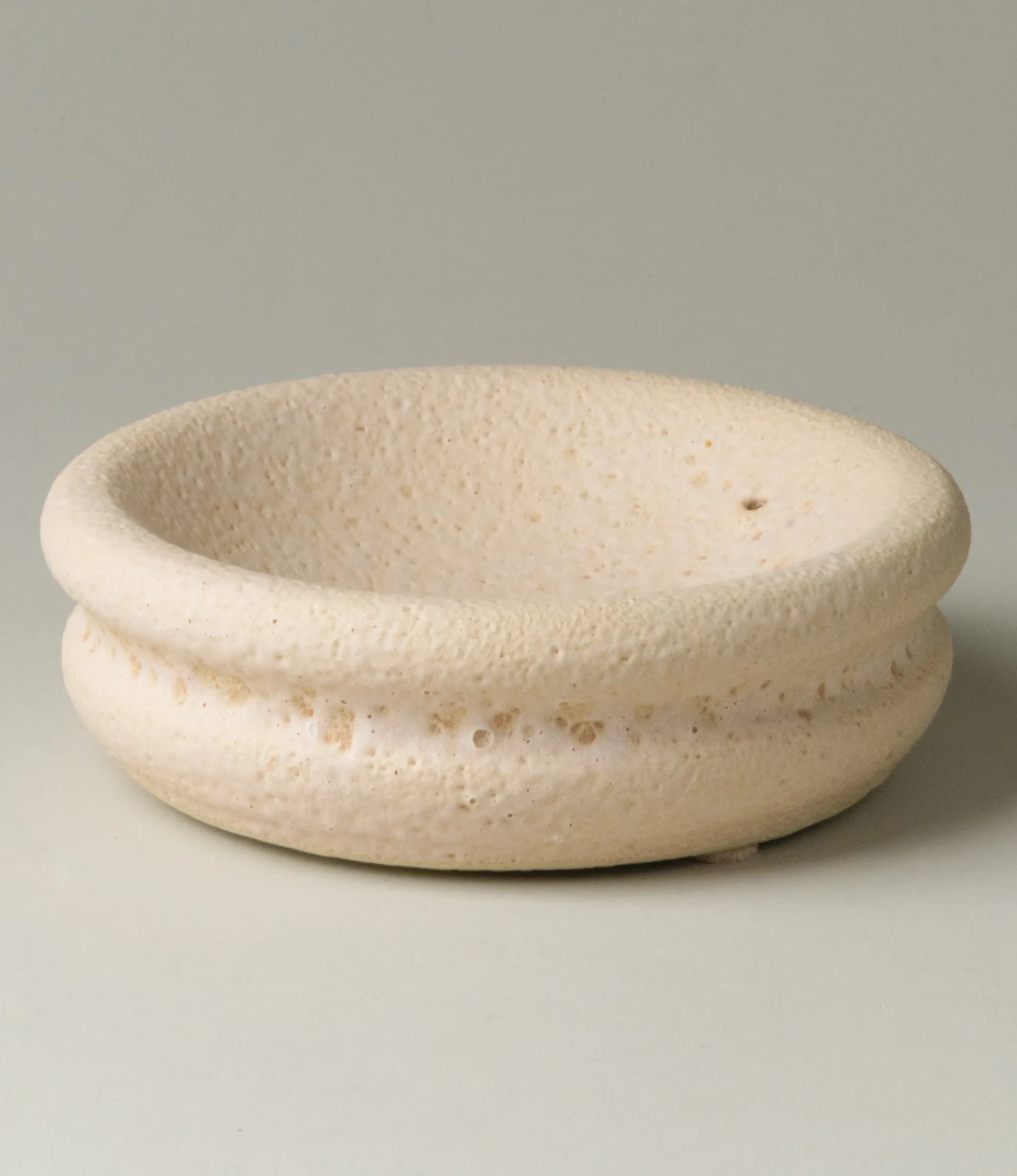 Lyot Incense Holder designed by Ocactuu has a sand texture and comes in a light nude color. The rounded plate has the place for your incense close to the edge of it.