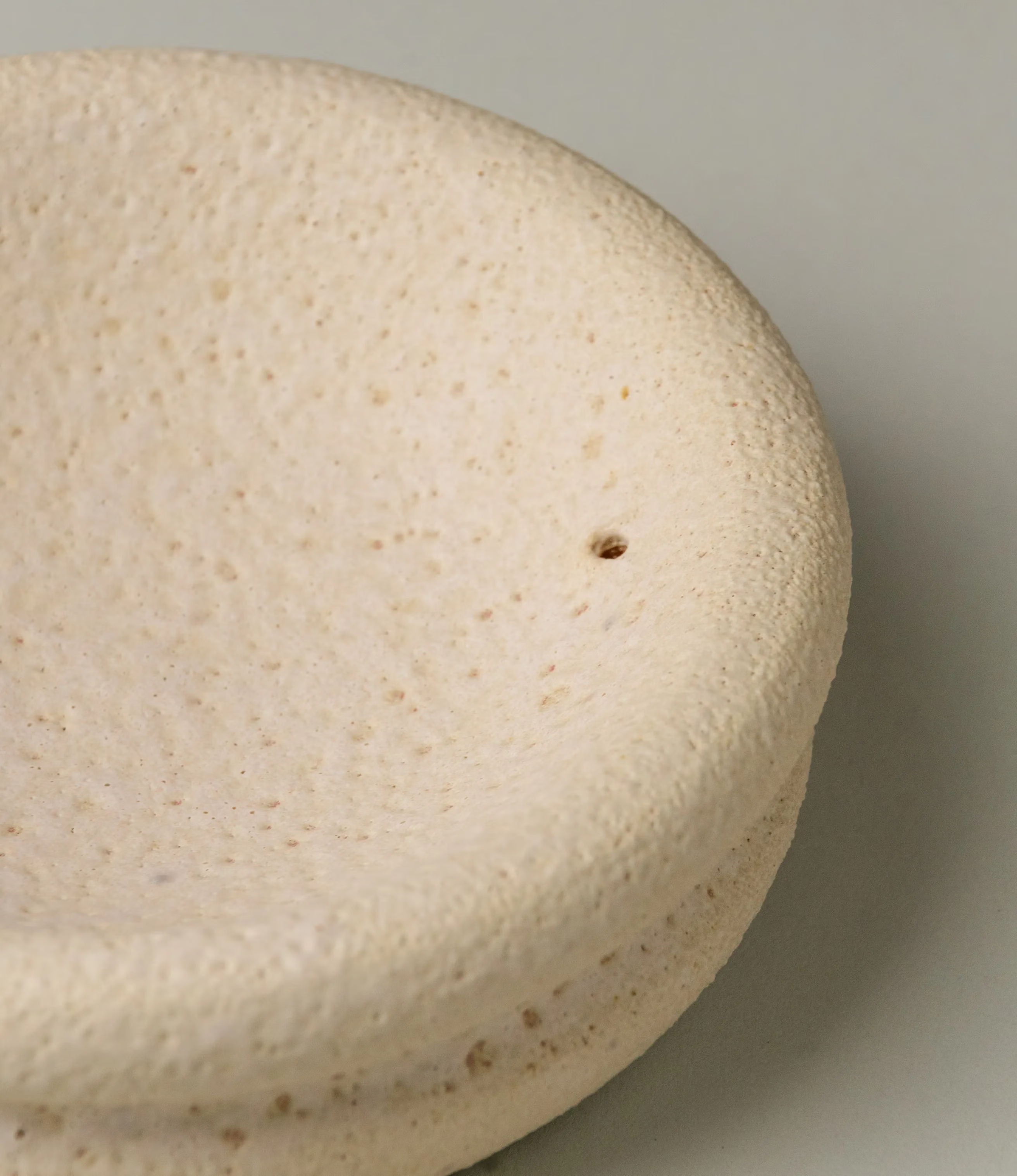 Lyot Incense Holder designed by Ocactuu has a sand texture and comes in a light nude color. The rounded plate has the place for your incense close to the edge of it.