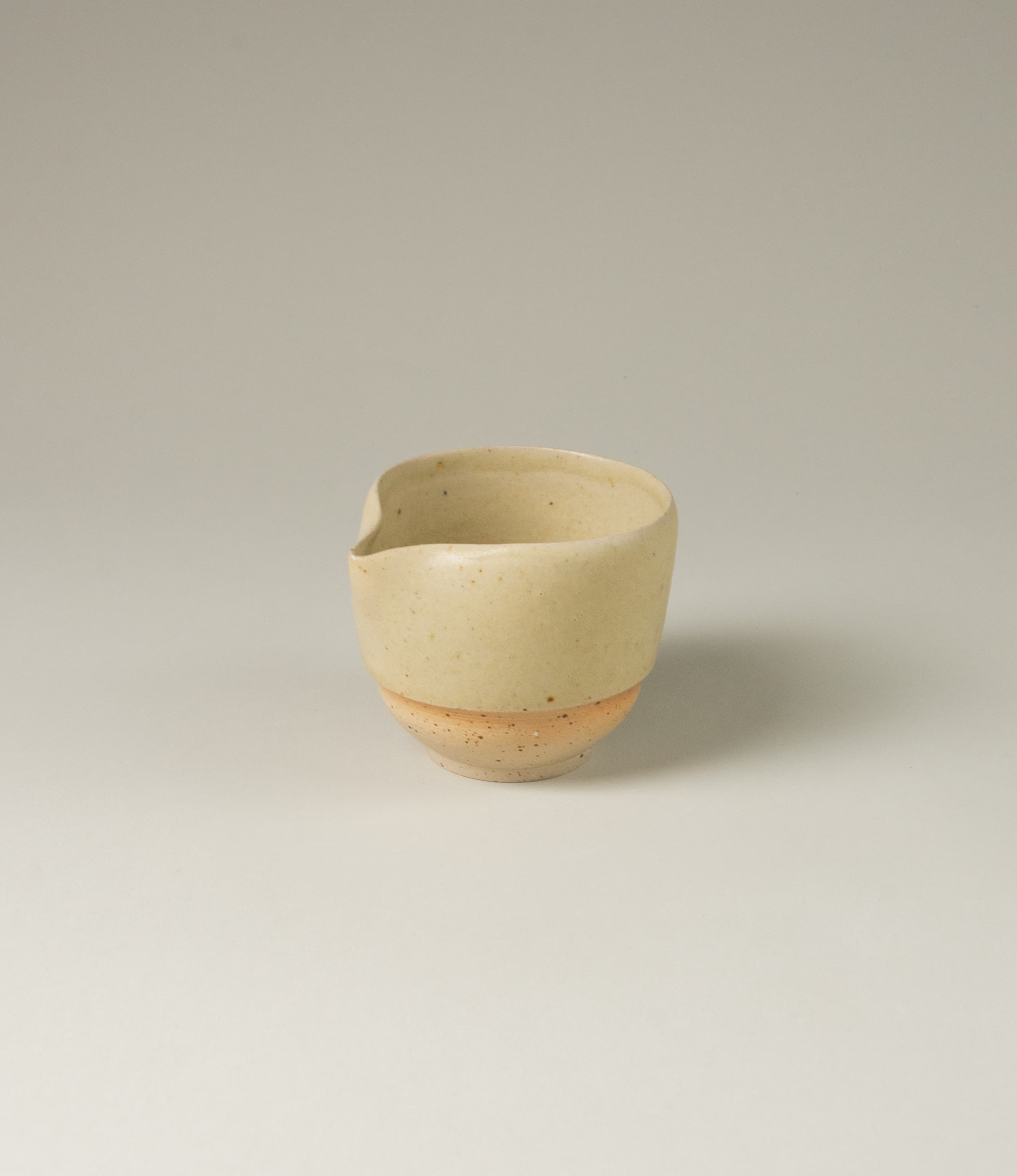 A pourer from Omni Ceramics, handmade in Belgium with an attention to detail. The product comes in a light beige natural color, with a painted orange gradient ring. The item is perfect to prepare your morning matcha tea.