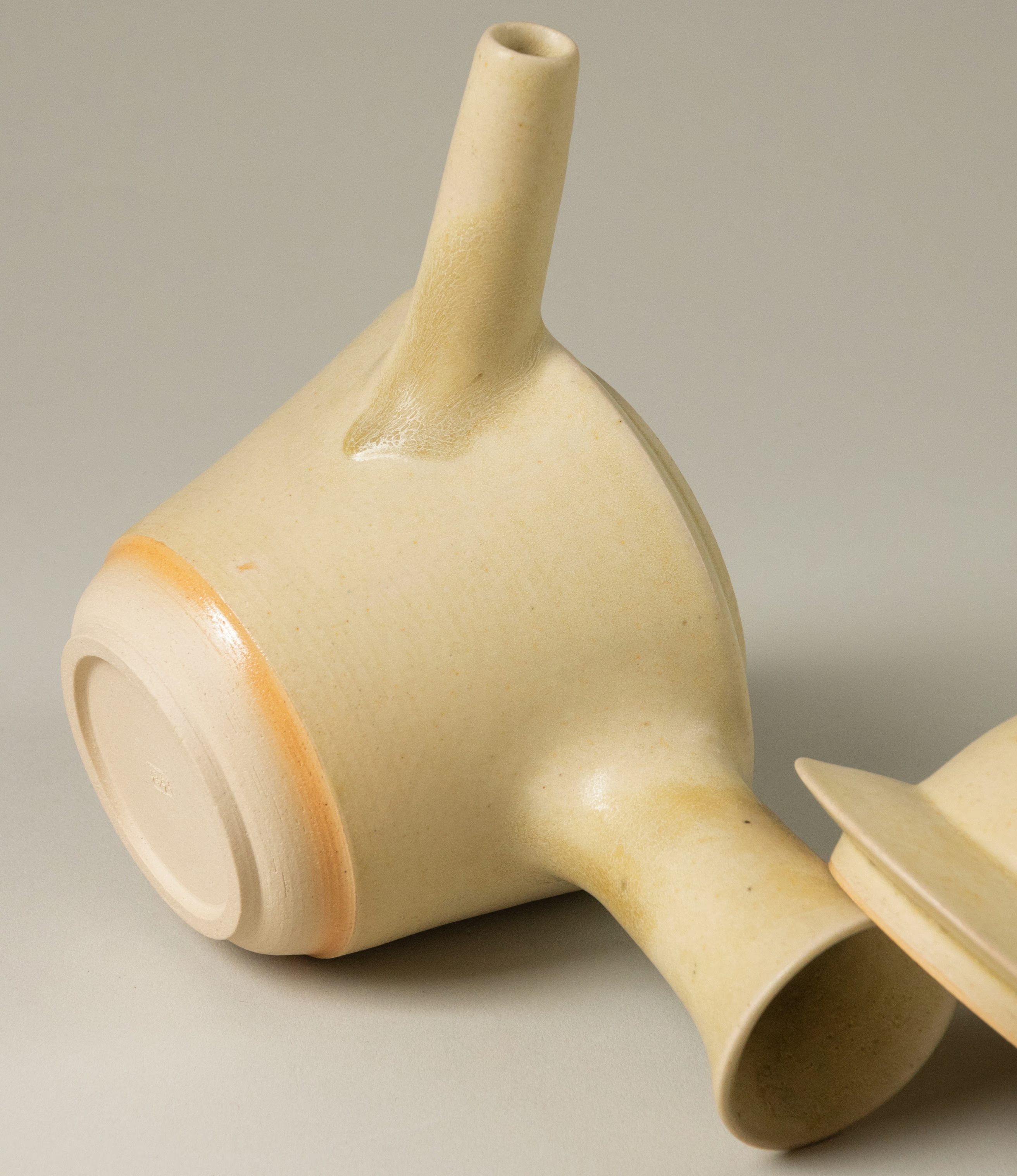 Detail shot of Omni Ceramic's teapot. The picture showcases the unique orange gradient ring on the lower part of the product.