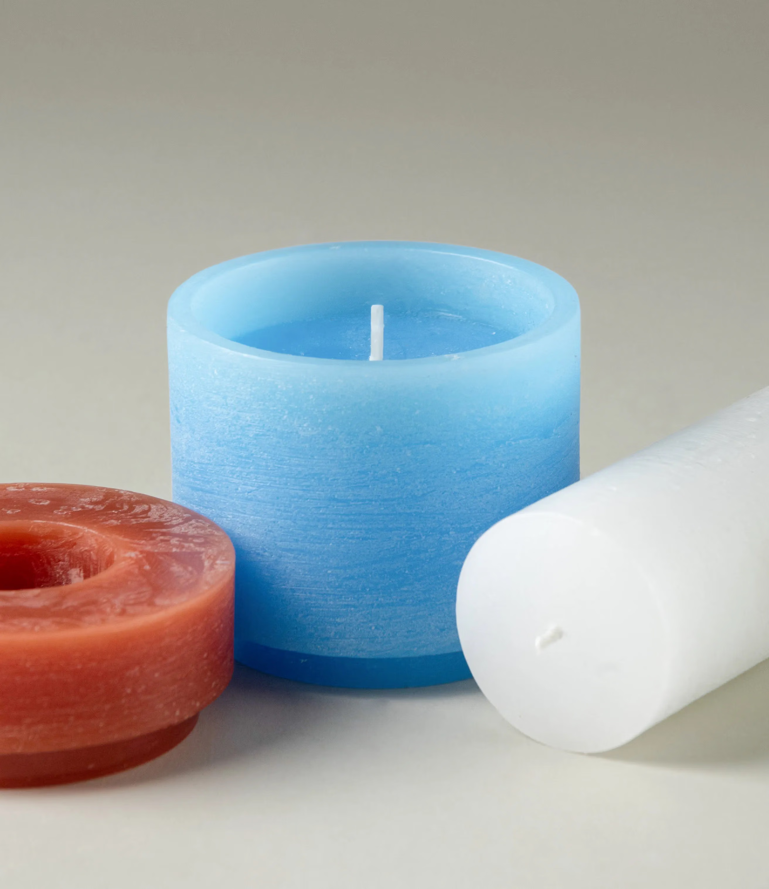 Stackable candle from Stan Editions. This particular piece comes in the color of burgundy, blue and white. The product consists of three pieces, they are unassembled on this picture. The texture of the product is rough gives a brushed effect.