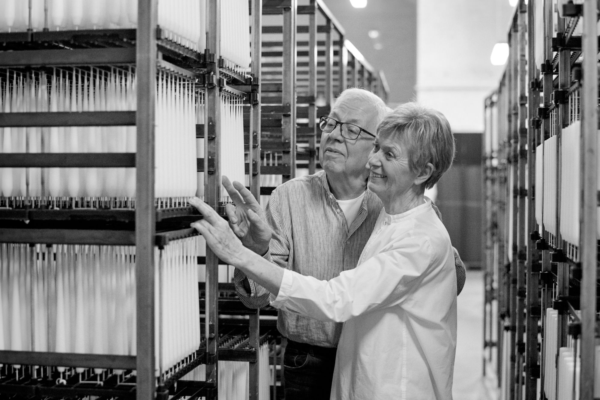 Ester and Erik founders next to their handmade candles in a production rack